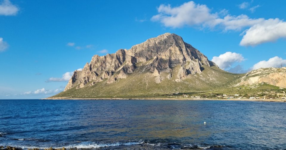 Monte cofano visto dalla baia di Cornino. In primo piano il mare azzurro.