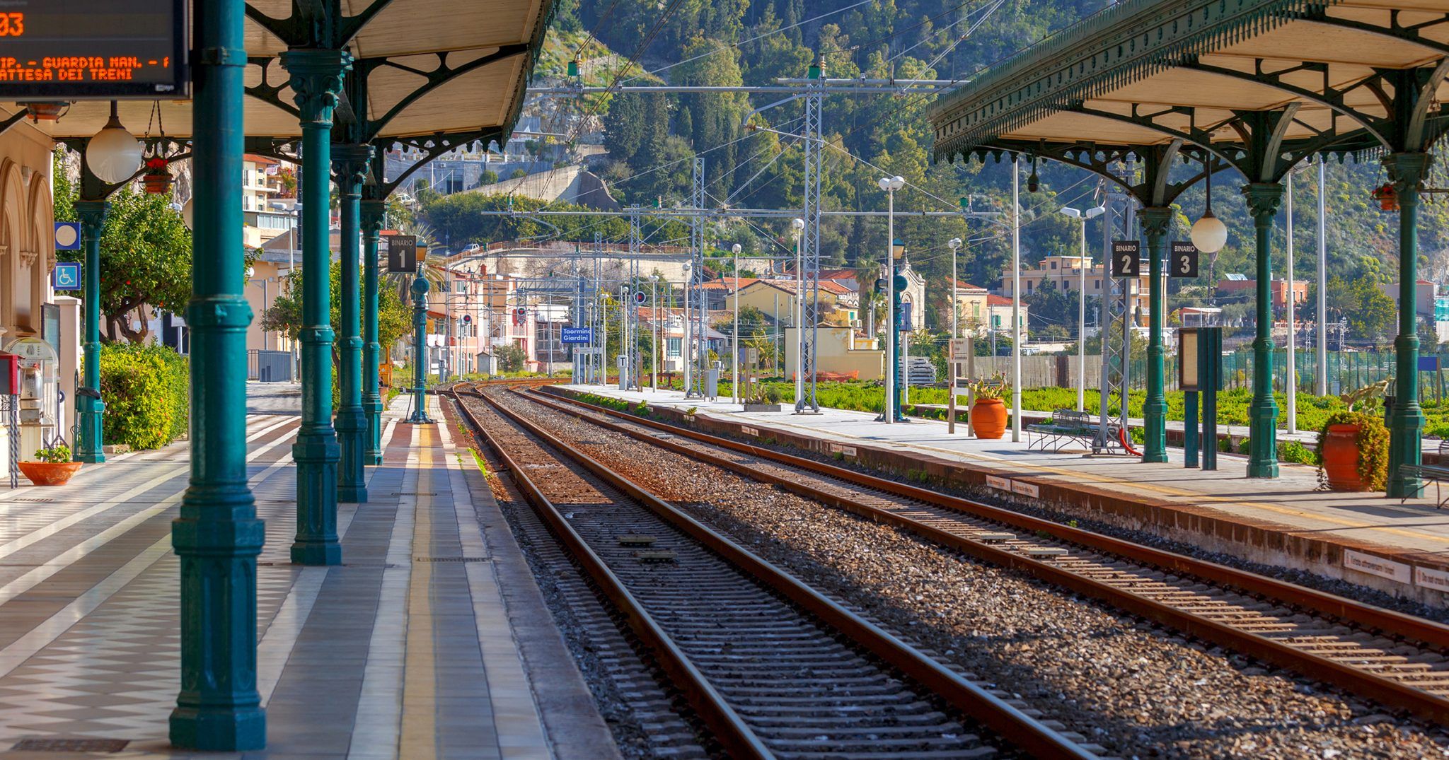 Una stazione ferroviaria con panchine e un cartello sul muro foto