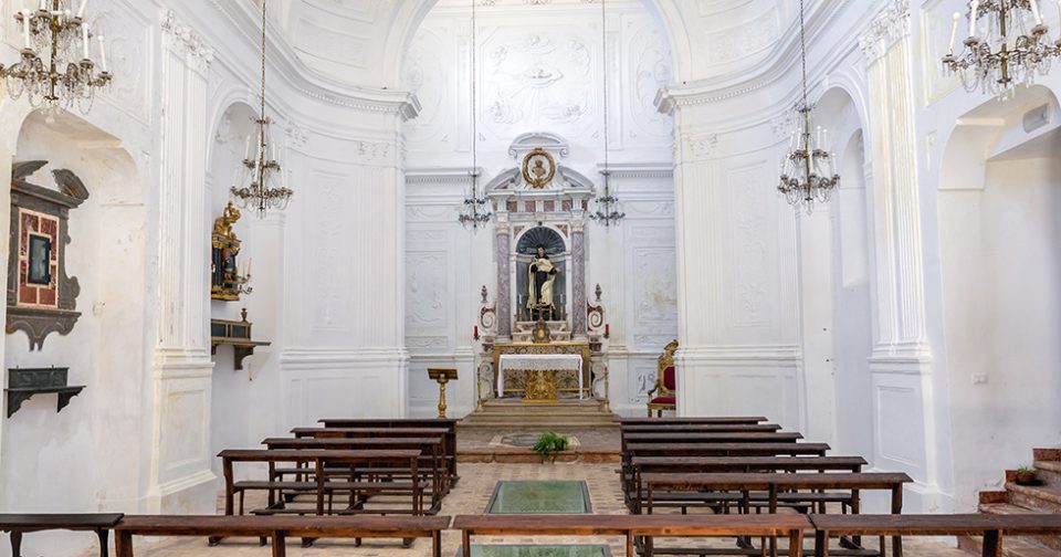 Altare maggiore della chiesa di Sant'Alberto. Sul fondo altare in marmo con nicchia e statua del santo. Ai lati stucchi decorativi bianchi.