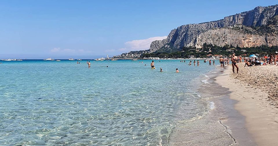 La Spiaggia siciliana di Mondello. In primo piano mare trasparente e sabbia bianca.