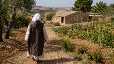 Suor Elisa di spalle cammina verso l’eremo sull’altopiano di Salemi