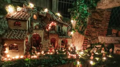 Presepe di quartiere a San Fratello illuminato di sera, con casette in pietra, tetti di coppi e pastori